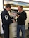 Mr. Brad Boland (right), President O-Neill Transfer and Storage Co., hands off a bottle of 1945 Calvados brandy to Master Sgt. Todd Wivell, 62nd Airlift Wing chief of public affairs, March 5, 2017 at the O-Neill business office in Beaverton, Oregon. Boland, along with other members from the east coast to the west coast, assisted in transporting two separate bottles of this brandy in order to help two World War II veterans complete a pact to toast their fallen comrades. (Courtesy photo
