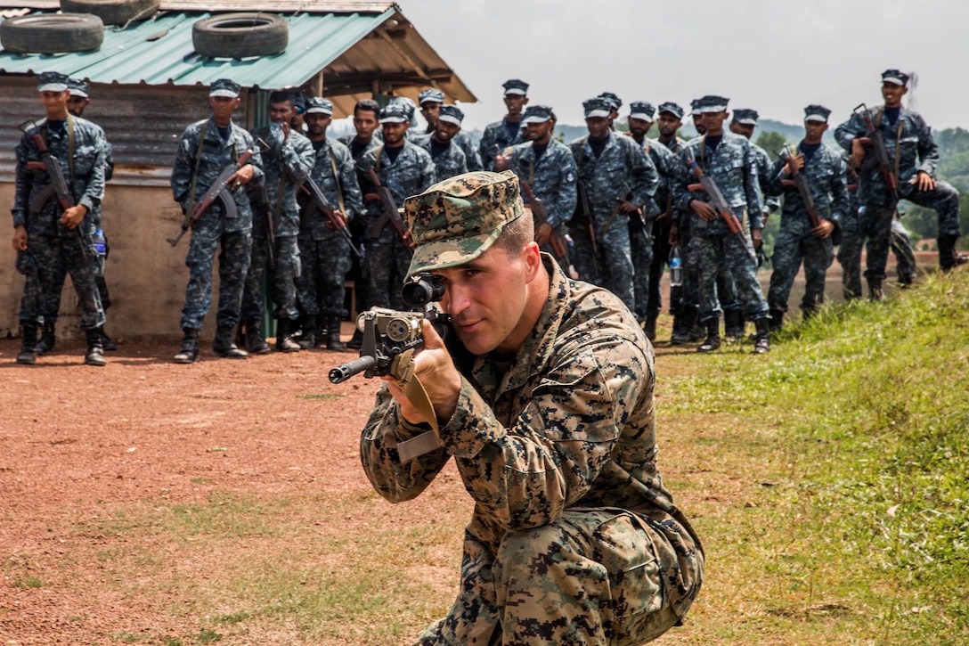 U.S. Marine Cpl. Benjamin Hartsell, foreground, demonstrates the proper kneeling position while providing security for his squad during the patrolling portion of a military tactics training and exchange, part of a theater security cooperation engagement at Welissara Naval Base, Sri Lanka, March 29, 2017. Hartsell is a rifleman assigned to Bravo Company, 1st Battalion Landing Team, 4th Marines, 11th Marine Expeditionary Unit. Marine Corps photo by Cpl. Devan K. Gowans 