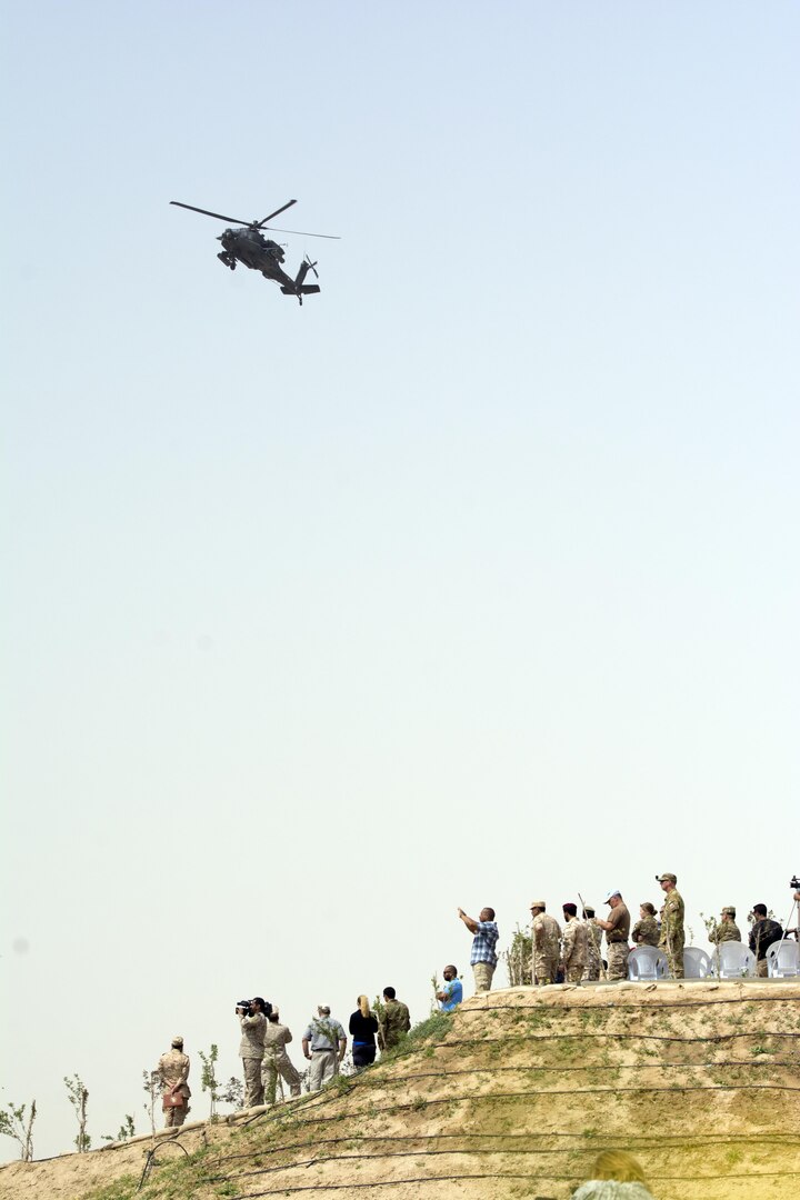 Kuwait- A AH-64, Apache, supporting 77th Combat Aviation Brigade, hovers above a large crowd of foreign and U.S. dignitaries gathered to view teams from their combined special forces- Qatar, Kuwait, Saudi Arabia and the United States, during an explosive training mission  proving the successful interoperability of both land and air assets as well as highlighting the vast skills of the varied partner nations part of Operation Eagle Resolve, April 2. 
(Photo by Army Sgt. 1st Class Suzanne Ringle/Released)