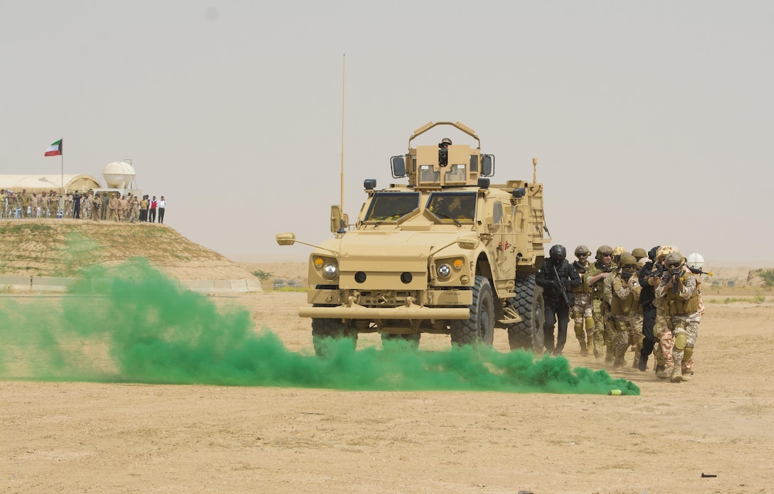 Kuwait- A large crowd of foreign and U.S. dignitaries view teams from their combined special forces- Qatar, Kuwait, Saudi Arabia and the United States, use smoke and an armored vehicle for concealment during an explosive training mission  proving the successful interoperability of both land and air assets as well as highlighting the vast skills of the varied partner nations part of Operation Eagle Resolve, April 2. 
(Photo by Army Sgt. 1st Class Suzanne Ringle/Released)