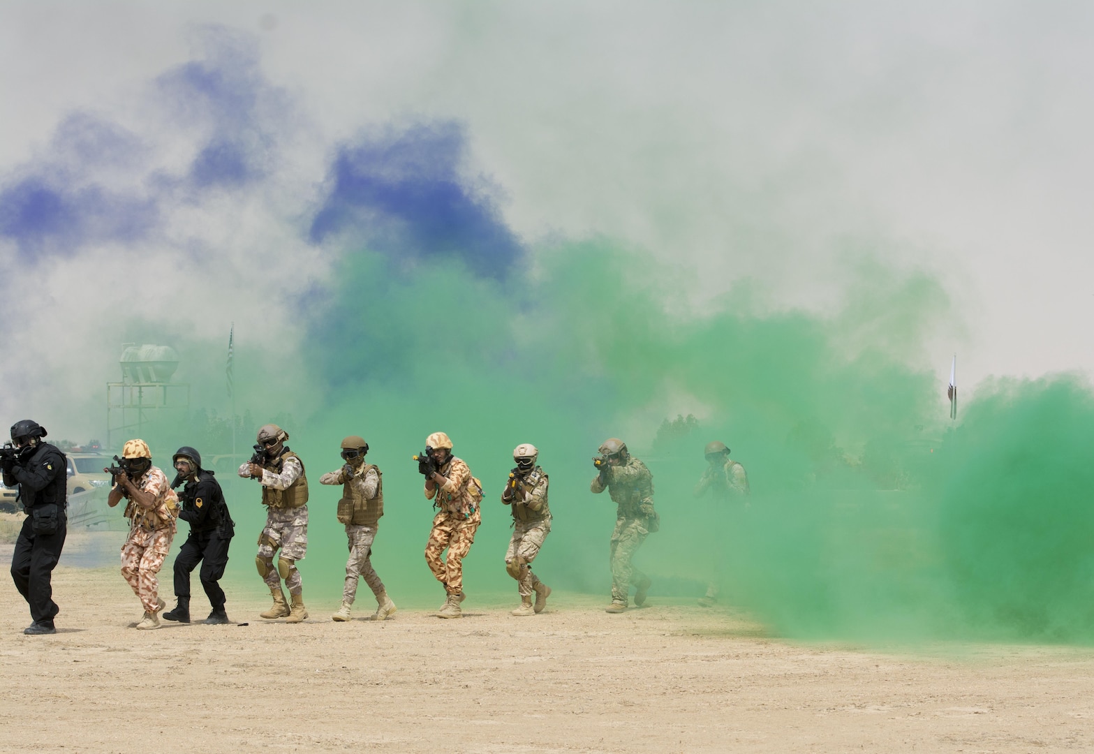 Kuwait- A large crowd of foreign and U.S. dignitaries’ view teams comprised of their combined special forces emerge from a purple and green smoke screen during an explosive training mission demonstrating the successful interoperability of Qatar, Kuwait, Saudi Arabia and the United States as partner nations and part of Operation Eagle Resolve involving both land and air elements, April 2. 
(Photo by Army Sgt. 1st Class Suzanne Ringle/Released)