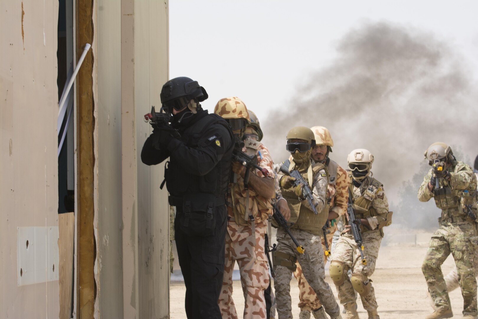 Kuwait- A large crowd of foreign and U.S. dignitaries view teams from their combined special forces- Qatar, Kuwait, Saudi Arabia and the United States, prepare to clear a building and subdue combatants during an explosive training mission proving the successful interoperability of both land and air assets as well as highlighting the vast skills of the varied partner nations part of Operation Eagle Resolve, April 2. 
(Photo by Army Sgt. 1st Class Suzanne Ringle/Released)