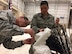 Airman 1st Class Kyle Stephens, hydraulics journeyman with the evaluation team, guides Col. Ben Maitre (left), the base commander, through a repair process on a Variable Speed Drogue assembly, March 7, 2017. Cannon Air Force Base has been the leading edge in testing the VSD, which provides a gap-filler capability to refuel aircraft between low and high speeds; enabling more flexibility for mission support. (U.S. Air Force photo by Tech. Sgt. Manuel J. Martinez)

