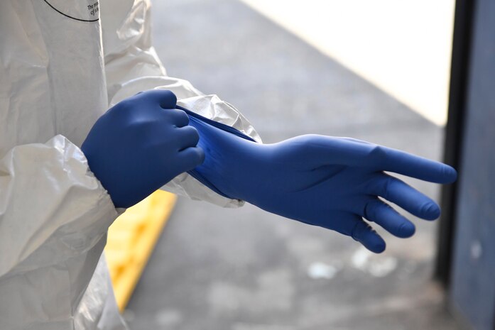 James Bundo, Medical University of South Carolina team leader, puts on a glove during a communicable disease exercise at the Charleston, S.C. Federal Law Enforcement compound April 4, 2017. The exercise, the first of its kind here, tested communication procedures and the integration of federal, state, local and private industry partners while analyzing response capabilities if an infected person needed to be transported from a vessel to the Port of Charleston. 