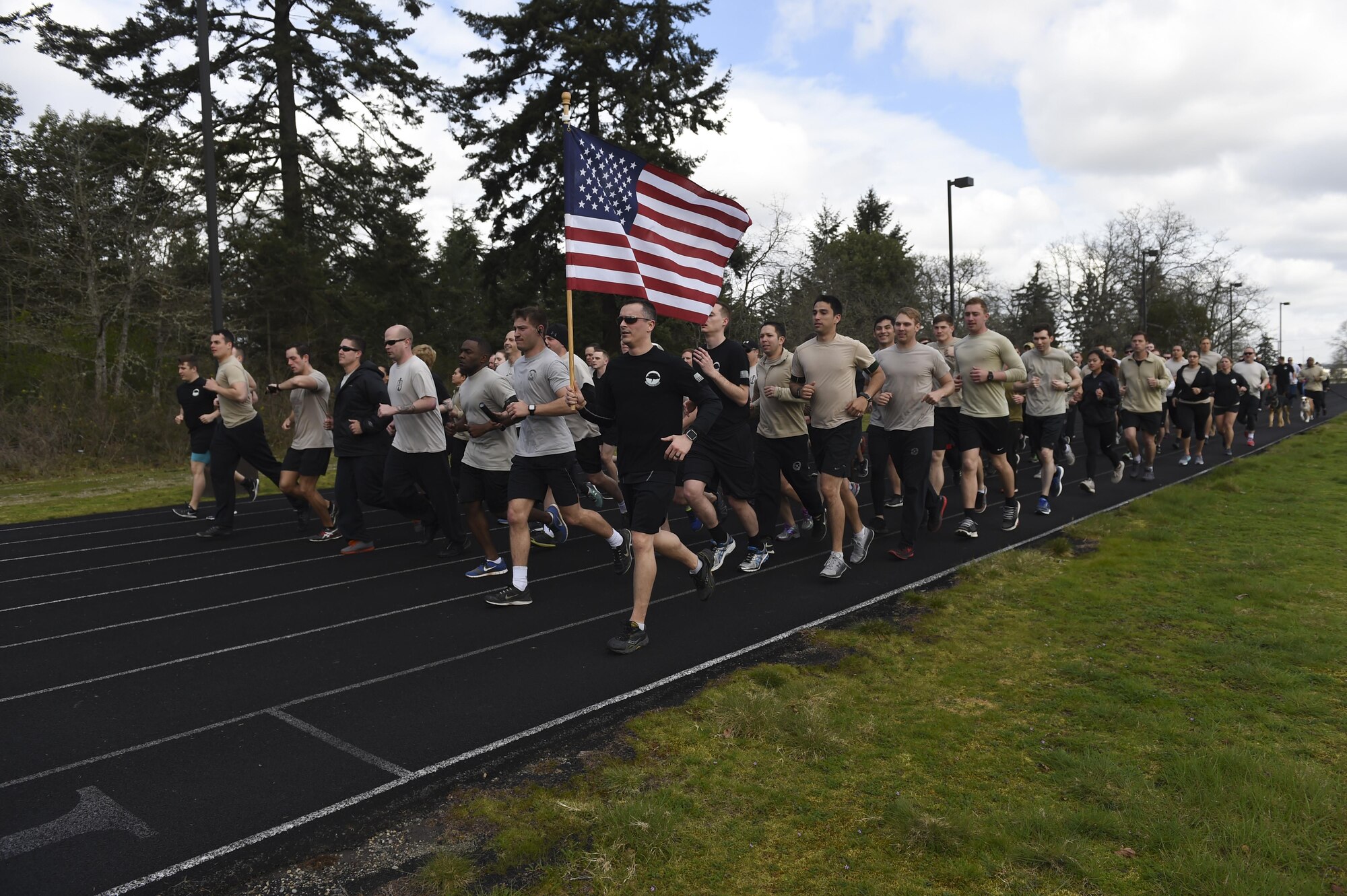 More than 200 members of the 1st Air Support Operations Group, 194th ASOG, 62nd Airlift Wing and Joint Base Lewis- McChord, Wash., both military and civilian, run their last lap of the Tactical Air Control Party 24-hour memorial run at Joint Base Lewis-McChord, Wash., on March 31, 2017. In total they raised approximately $6,000 dollars towards the TACP-Association that has given more than $200K back to the community and their families. (Air Force Photo/ Staff Sgt. Naomi Shipley)