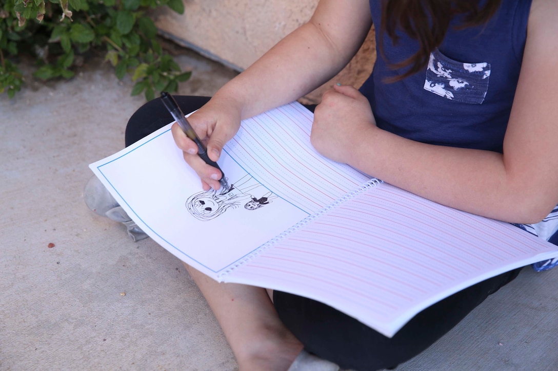 Aubrey Rudd, 7 years old, daughter of Jessica Rudd, Armed Forces Insurance Marine Spouse of the Year 2017 presented by Military Spouse Magazine, draws a photo of herself and her younger sister, Molly, 10 months old, at their home in Yucca Valley, Calif., March 29, 2017, Jessica, a Marine veteran, wife and mother of three, was chosen as the 2017 MSOY for her dedication to helping improve the quality of life of military members and their spouses. (U.S. Marine Corps photo by Cpl. Medina Ayala-Lo)