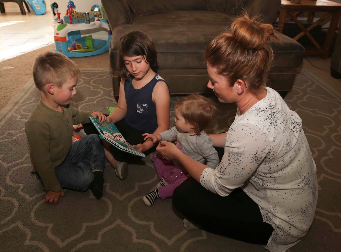 Jessica Rudd, Armed Forces Insurance Marine Spouse of the Year 2017 presented by Military Spouse Magazine, reads a book with her children at their home in Yucca Valley, Calif., March 29, 2017. Rudd, a Marine veteran, wife and mother of three, was chosen as the 2017 MSOY for her dedication to helping improve the quality of life of military members and their spouses. (U.S. Marine Corps photo by Cpl. Medina Ayala-Lo)