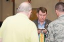 Members of the 307th Bomb Wing alumni groups attached streamers to the 307th Maintenance Squadron&#39;s guidon representing awards received during World War II, the Korean War, Vietnam and the Cold War during the 75th Anniversary Celebration. 