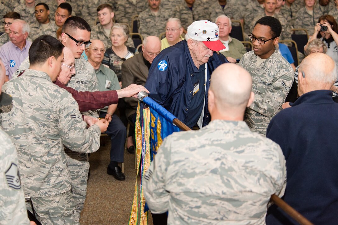 Members of the 307th Bomb Wing alumni groups attached streamers to the 307th Maintenance Squadron's guidon representing awards received during World War II, the Korean War, Vietnam and the Cold War during the 75th Anniversary Celebration. 