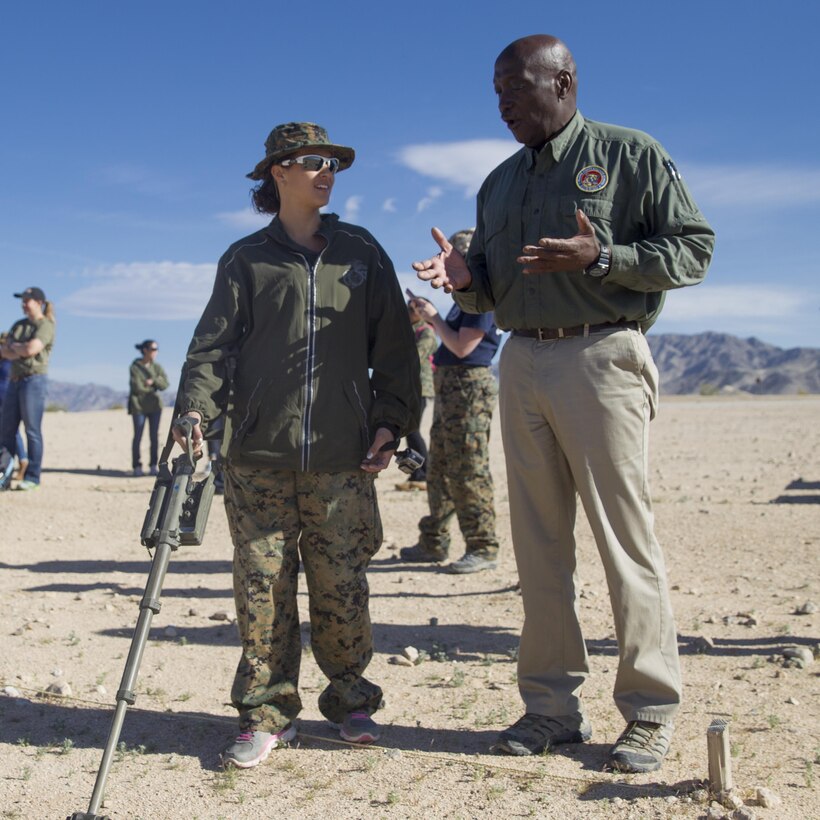 Melvin Harris, counter Improvised Explosive Device instructor, Marine Corps Engineer School, teaches Annie Smack, wife of Gunnery Sgt. Eric Smack, 3rd Battalion, 11th Marine Regiment, how to sweep for IEDs at Range 800 aboard Marine Corps Air Ground Combat Center, Twentynine Palms, Calif., March 30, 2017. (U.S. Marine Corps photo by Cpl. Connor Hancock)