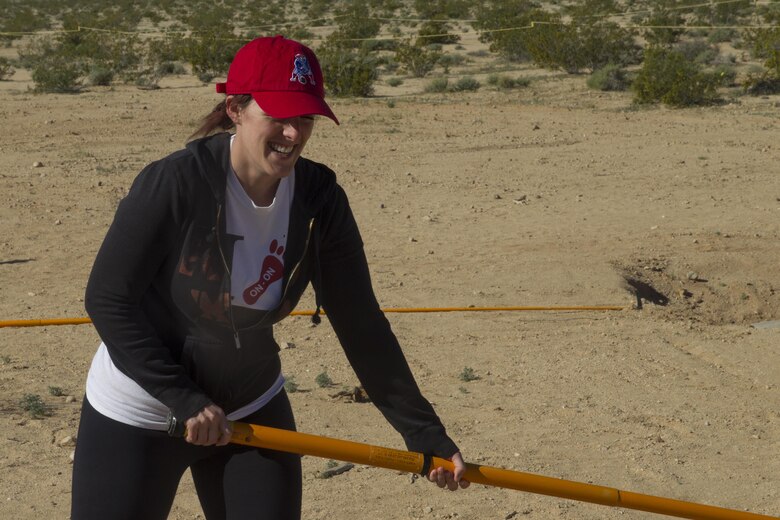 Annie Stump, wife of Sgt. Myles Stump, Marine Corps Communications Electronics School, uses a Holley stick at Range 800 aboard Marine Corps Air Ground Combat Center, Twentynine Palms, Calif., March 30, 2017. The Holley stick is a tool used exclusively by Marine Corps Explosive Ordnance Disposal technicians that provides them with the capability to investigate and manipulate a suspect IED from a stand-off distance.  (U.S. Marine Corps photo by Cpl. Connor Hancock)