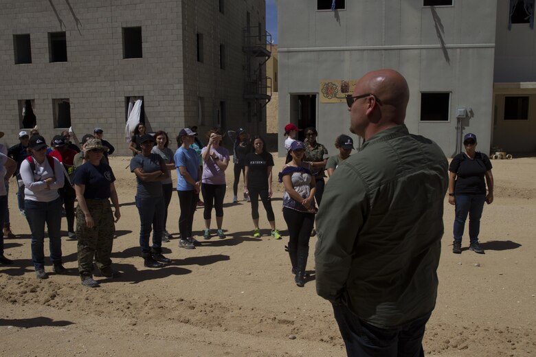 Adam Clancy, operations officer and tour manager, Government and External Affairs (G-5), escorts ITX for Spouses participants through Range 220 aboard Marine Corps Air Ground Combat Center, Twentynine Palms, Calif., March 30, 2017. (U.S. Marine Corps photo by Cpl. Connor Hancock)