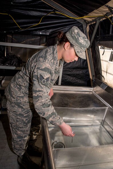 Senior Airman Paige Tranah, a services specialist with the 934th Force Support Squadron working at the Dining Facility at Minneapolis-St. Paul Air Reserve Station, Mn., checks the water temperature for the sinks during the 2017 Hennessy competition. The competition involves setting up and operating a Single Pallet Expeditionary Kitchen used in the field to feed troops deployed to austere locations.