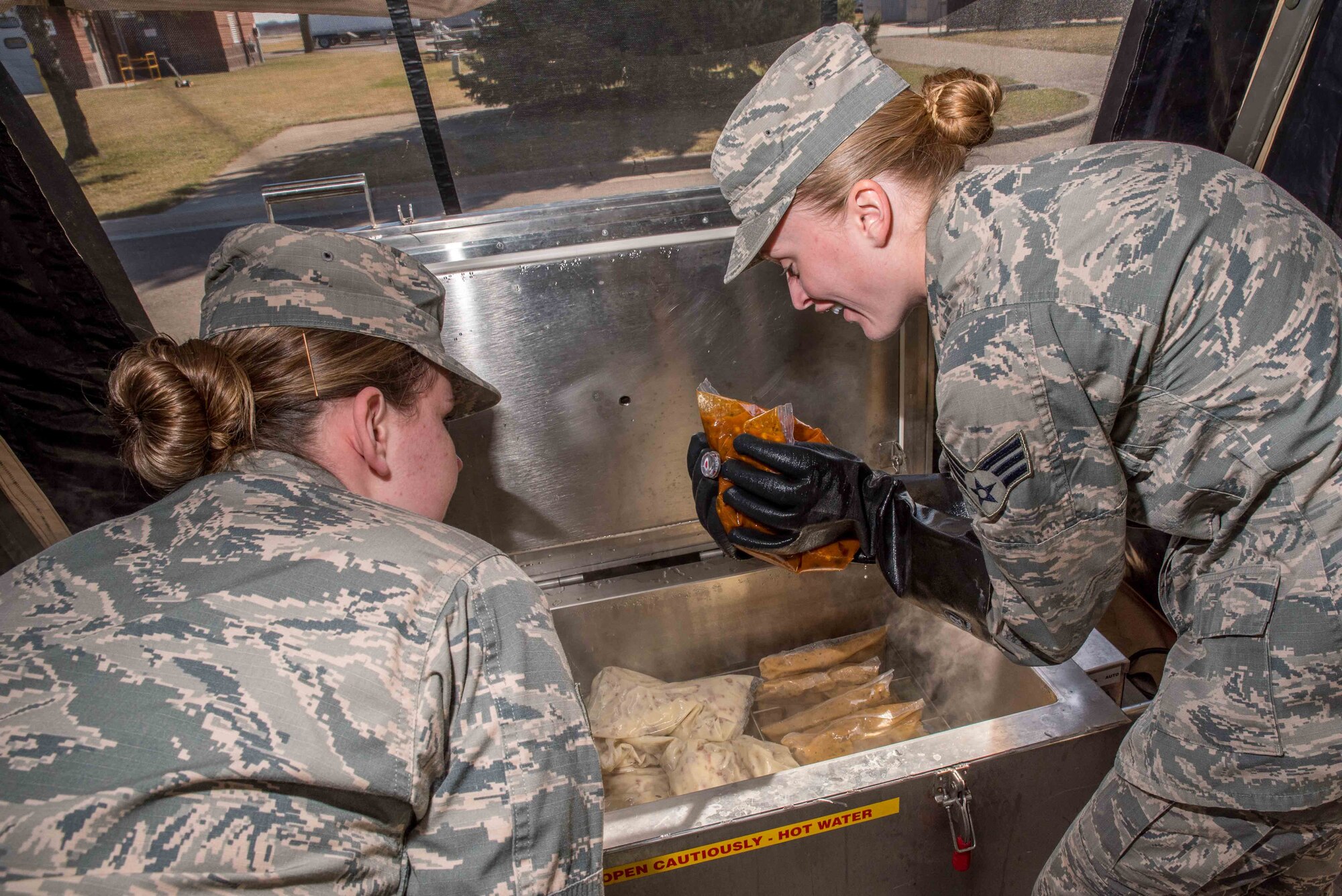 Senior Airman Sarah Overlin and Senior Airman Racheal Semanko, services specialists with the 934th Force Support Squadron working at the Dining Facility at Minneapolis-St. Paul Air Reserve Station, Mn., check the temperature of packaged food items being cooked during the 2017 Hennessy competition. The temperature is closely monitored during the cooking process to ensure food items are thoroughly cooked and safe for consumption. 