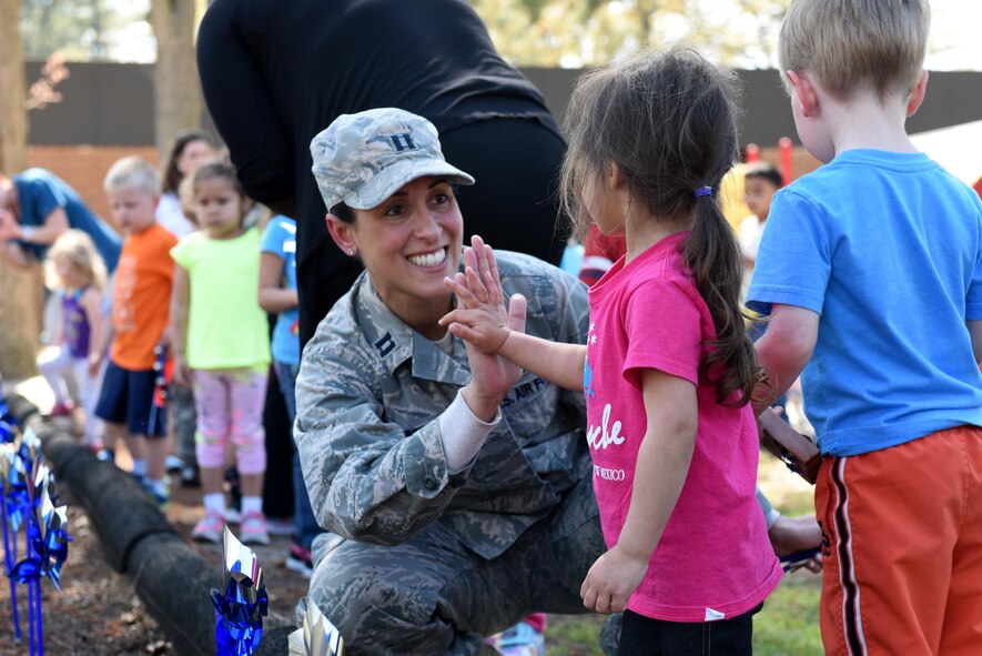 Capt. Christina A. Stabile, 4th Medical Operations Squadron mental health flight family advocacy officer, participates in a pinwheel parade event with children from the 4th Support Squadron Child Development Center in honor of Child Abuse Prevention Month, April 4, 2017, at Seymour Johnson Air Force Base, North Carolina. The children “planted” their pinwheels along the perimeter of the CDC playground to raise awareness for child abuse prevention.  (U.S. Air Force photo by Airman 1st Class Victoria Boyton)
