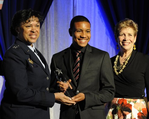 Eighteen-year-old Jamal Braxton receives the 2017 Air Force Military Child of the Year award during a gala in Pentagon City, Va., April 6, 2017, from Air Force Assistant Vice Chief of Staff Lt. Gen. Stayce Harris and Ellyn Dunford, spouse of Chairman of the Joint Chiefs of Staff Gen. Joseph F. Dunford Jr. The annual event celebrates military children who demonstrate leadership, resilience and strength of character, as well as an ability to thrive when dealing with the challenges inherent in military family life. (U.S. Air Force photo/Staff Sgt. Jannelle McRae)