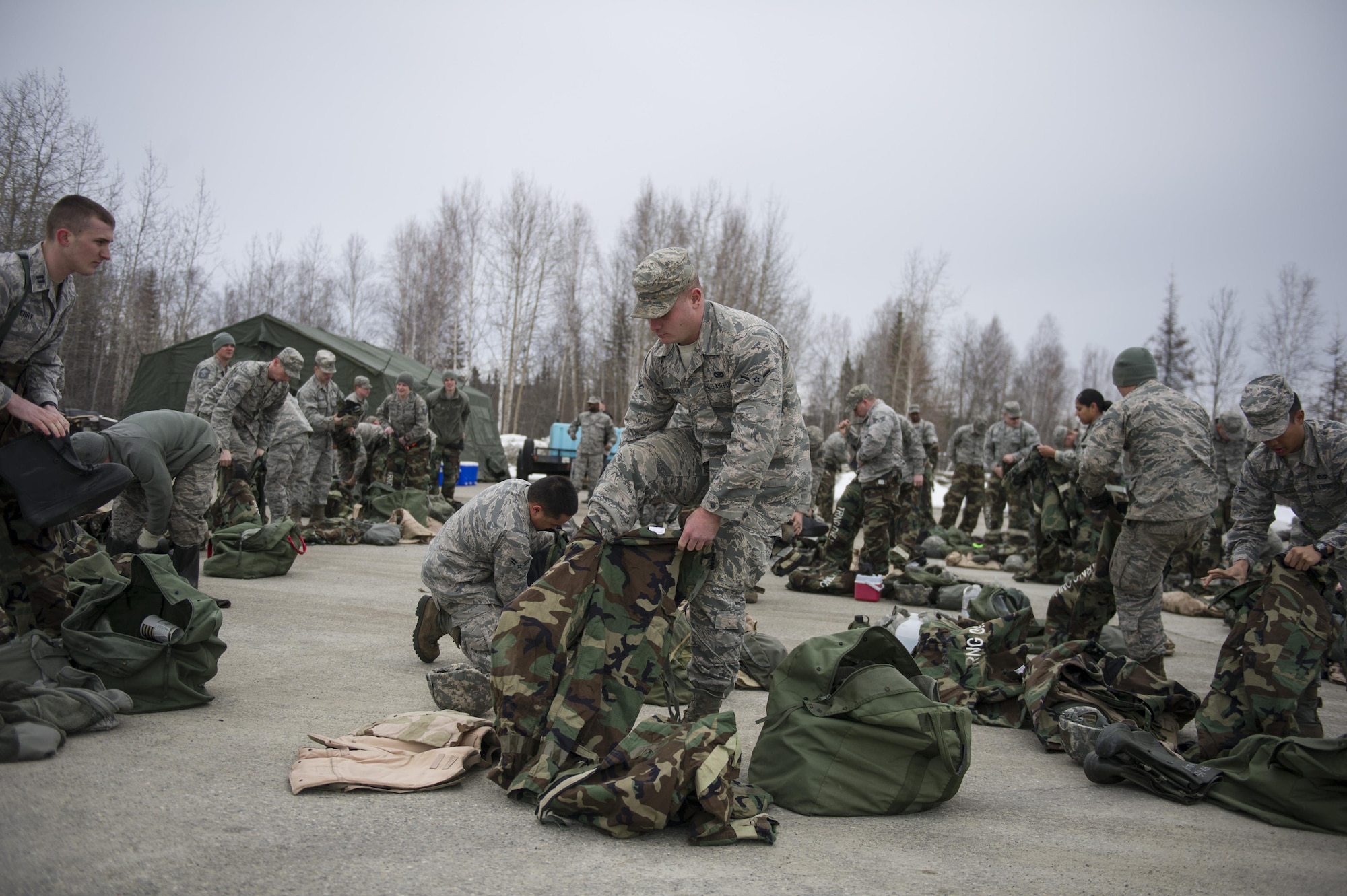 U.S. Air Force Airman Austin Romanov, a 354th Civil Engineer Squadron electrical systems apprentice, puts on his mission-oriented protective posture gear for chemical warfare training during exercise Arctic Gold 17-5 (AG) April 6, 2017, at Spruce Lake on Eielson Air Force Base, Alaska. Airmen from all around the base participated in the chemical warfare training in support of AG 17-5. (U.S. Air Force photo by Airman 1st Class Isaac Johnson)