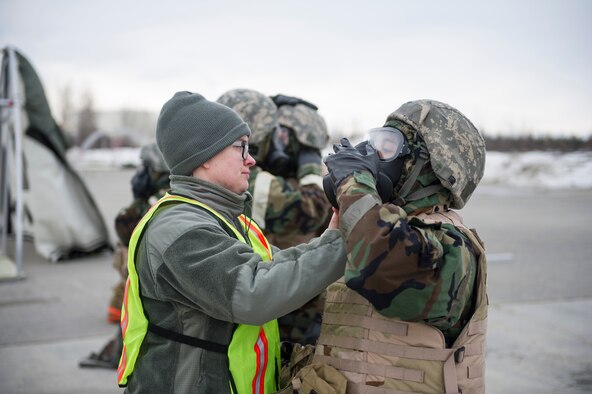 U.S. Air Force Senior Airman Stefanie Nakoneczny-Wood, a 354th Civil Engineer Squadron emergency management journeyman, inspects an Airman’s mission-oriented protective posture gear during exercise Arctic Gold 17-5 April 6, 2017, at Spruce Lake on Eielson Air Force Base, Alaska. During this portion of the training, Airmen had to get into full gear anytime they heard the siren go off. (U.S. Air Force photo by Airman 1st Class Isaac Johnson)