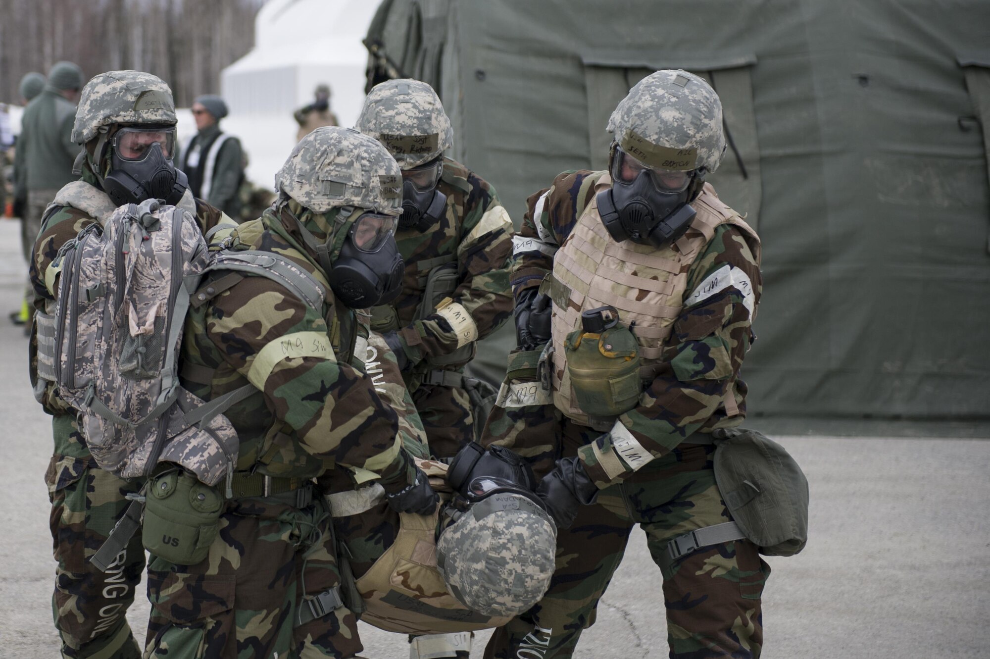 U.S. Air Force Airmen from the 354th Fighter Wing, transport a simulated casualty to safety during chemical warfare training for exercise Arctic Gold 17-5 April 6, 2017, at Spruce Lake on Eielson Air Force Base, Alaska. During the training Airman diagnosed, provided self-aid buddy care and transported simulated casualties while in full mission-oriented protective posture gear. (U.S. Air Force photo by Airman 1st Class Isaac Johnson)
