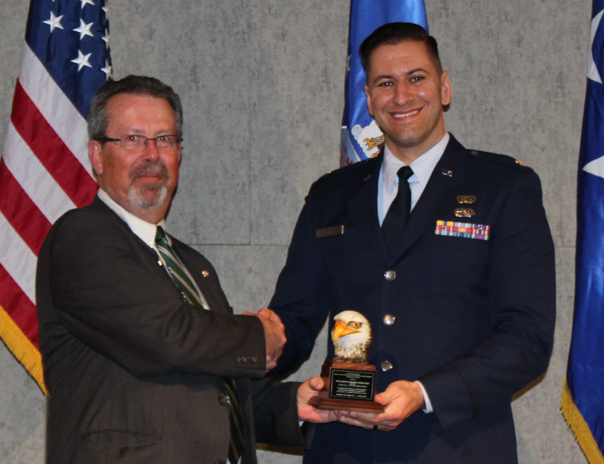 Maj. Nicholas Jamroz, deputy branch chief of the Space Based Infrared Systems Geosynchronous Earth Orbit Satellite office, accepts the AFA 2017 Brent Scowcroft Award for Space and Air Dominance Acquisition and Sustainment – Team on behalf of the directorate from retired Air Force Col. Robert George, Air Force Association Rocky Mountain Region President. (Courtesy photo)