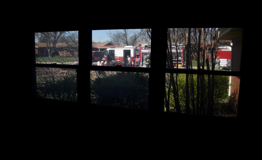 Firefighters assigned to the 22nd Civil Engineer Squadron prepare to complete a training exercise April 6, 2017, in base housing at McConnell Air Force Base, Kan. The firefighters used a vacant house that is scheduled for demolition during training to simulate a real-world emergency situation. (U.S. Air Force photo/Airman 1st Class Erin McClellan)