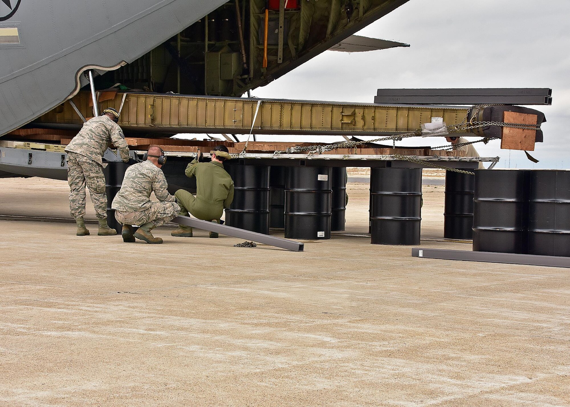 Airmen from the 143d Airlift Wing's Maintenance Group, Operations Group and Logistics Readiness Squadron work together to plan and complete the offload of a detached C-130 wing from the back of a C-130J using the Combat Offload Method B technique. The wing was secured to be used for training by Fuel Cell Airmen, Safety, and Fire personnel.