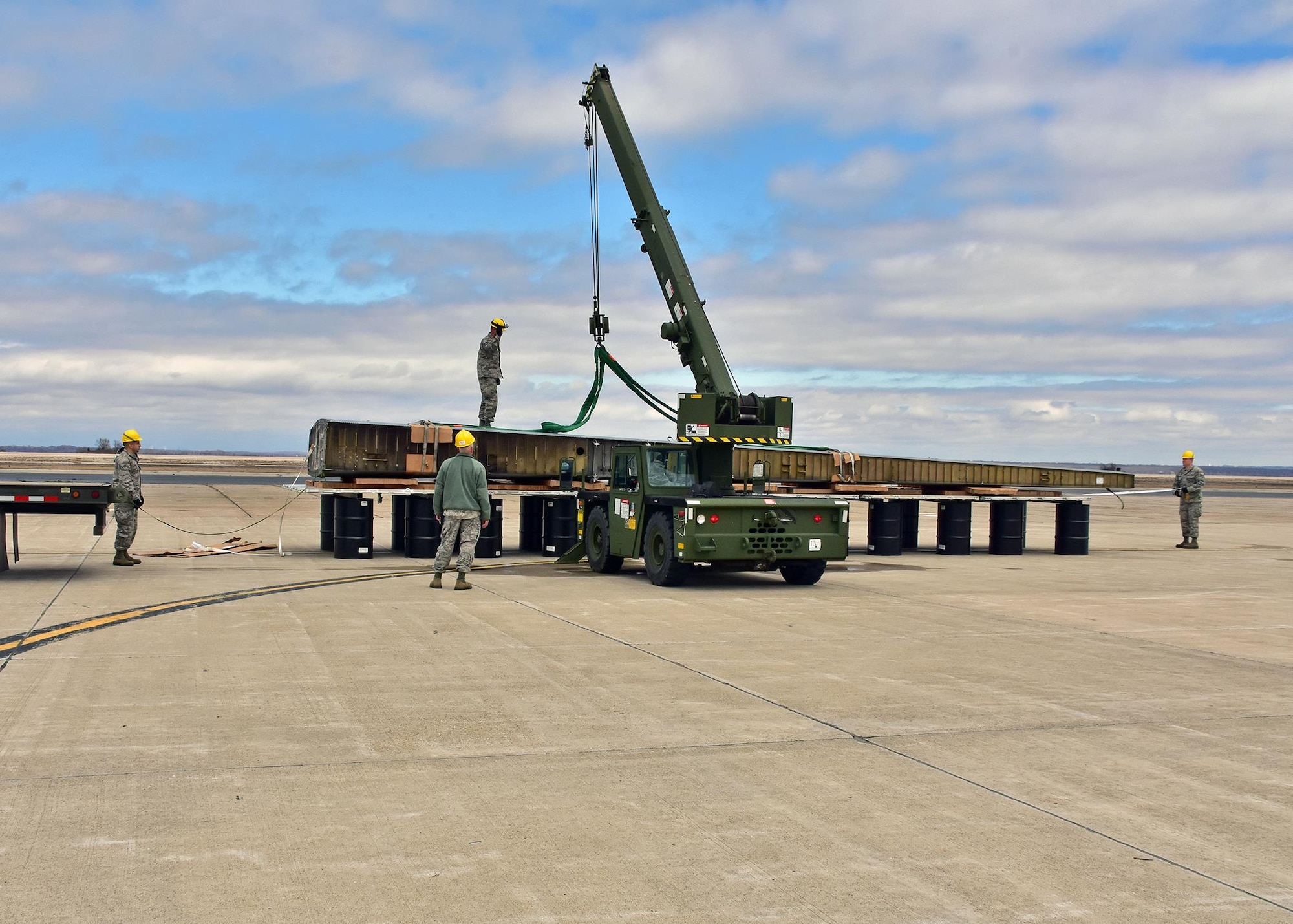 Airmen from the 143d Airlift Wing's Maintenance Group, Operations Group and Logistics Readiness Squadron work together to plan and complete the offload of a detached C-130 wing from the back of a C-130J using the Combat Offload Method B technique. The wing was secured to be used for training by Fuel Cell Airmen, Safety, and Fire personnel.