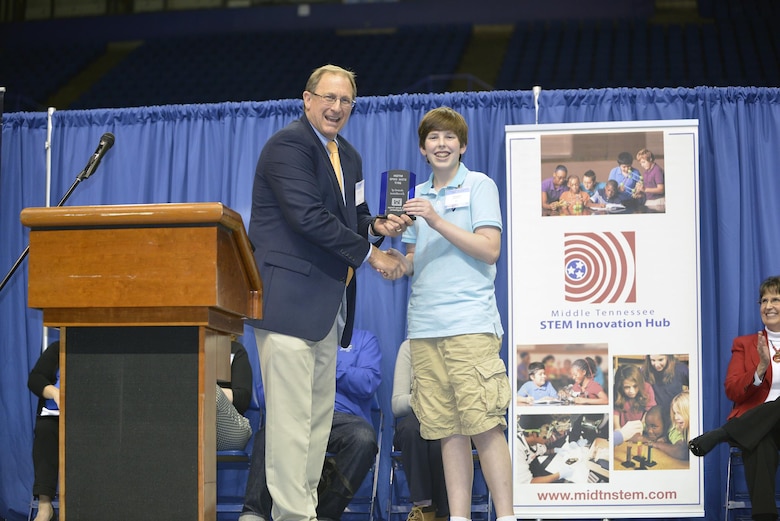 Jimmy Waddle, U.S. Army Corps of Engineers Nashville District Engineering and Construction Division chief, presents an award to Carson Fisher, 7th grade student from Robert E. Ellis Middle School in Hendersonville, Tenn., during the Science, Technology, Engineering and Mathematics Expo at Tennessee State University Gentry Center April 6, 2017.   He was presented with a glass trophy and certificate for his project, a self-rising levee system. 