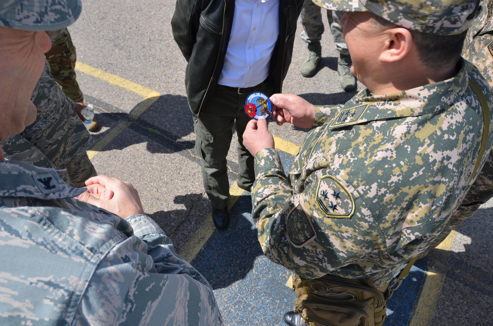 Air Force Col. Troy Daniels (left), vice commander of the 161st Air Refueling Wing, gives a unit patch to a military officer from the Republic of Kazakhstan as a memento, March 31. The wing hosted a Kazakh delegation visit to exchange ideas on emergency management. Kazakhstan and Arizona have been partners in the National Guard’s State Partnership Program since 1993. (U.S. Air National Guard photo by 2nd Lt. Tinashe Machona).