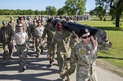 Members of the 350th Battlefield Airmen Training Squadron and from throughout Joint Base San Antonio-Lackland participated in a 1-mile log march during a memorial remembrance ceremony honoring Lt. Col. William “Bill” Schroeder April 7, 2017, at JBSA-Lackland, Texas, Medina Annex. Schroeder’s unit honored his legacy renaming a drop zone as Schroeder DZ and participated in a "Monster Mash" fitness competition, remembrance ceremony and log march. April 8, 2016, Schroeder recognized a perilous situation developing and reacted swiftly by putting himself between an armed individual and his first sergeant. In the process, he saved lives of other squadron members while being fatally wounded. Schroeder was posthumously awarded the Airman’s Medal, given to those that distinguish themselves by a heroic act – usually at the volunteer risk of their lives but not involving combat. (U.S. Air Force photo by Johnny Saldivar)

