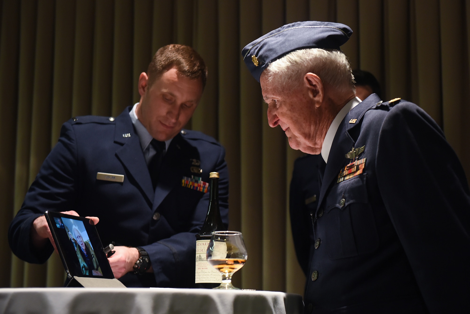 Maj. M. Eugene Johns and Col. Ralph Jenkins, WWII combat aviators and retired Air Force officers with the 510th Fighter Squadron, share a live-streamed greeting during a ceremony to toast their fallen Squadron members, Apr. 7, 2017, at Vandenberg Air Force Base, Calif. Personnel with the 510th FS made a pact that the last two surviving members of the unit who flew combat missions during WWII – Johns and Jenkins – would make a toast from two bottles of brandy which had been saved for the occasion. (U.S. Air Force photo by Michael Peterson/Released)