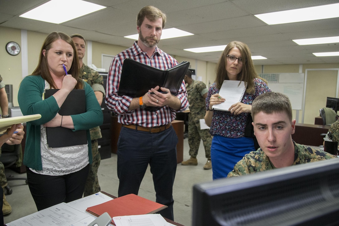 U.S. Marine Corps Lance Cpl. Christian Jacobs, procurement clerk, right, explains to the Marine Corps Administrative Analysis Team how he records information in the system at 1st Medical Logistics Battalion, 1st Marine Logistics Group, during a fiscal year 17 audit on Camp Pendleton, Calif., April 6, 2017. (U.S. Marine Corps photo by Lance Cpl. Betzabeth Y. Galvan)