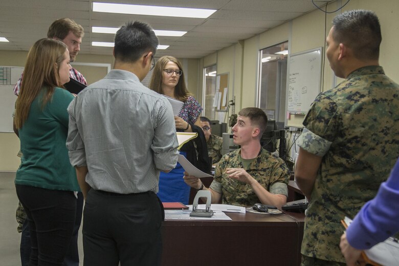 U.S. Marine Corps Lance Cpl. Christian Jacobs, procurement clerk, second from right, explains to the Marine Corps Administrative Analysis Team how he records information in the system at 1st Medical Logistics Battalion, 1st Marine Logistics Group, during a fiscal year 17 audit on Camp Pendleton, Calif., April 6, 2017. (U.S. Marine Corps photo by Lance Cpl. Betzabeth Y. Galvan)