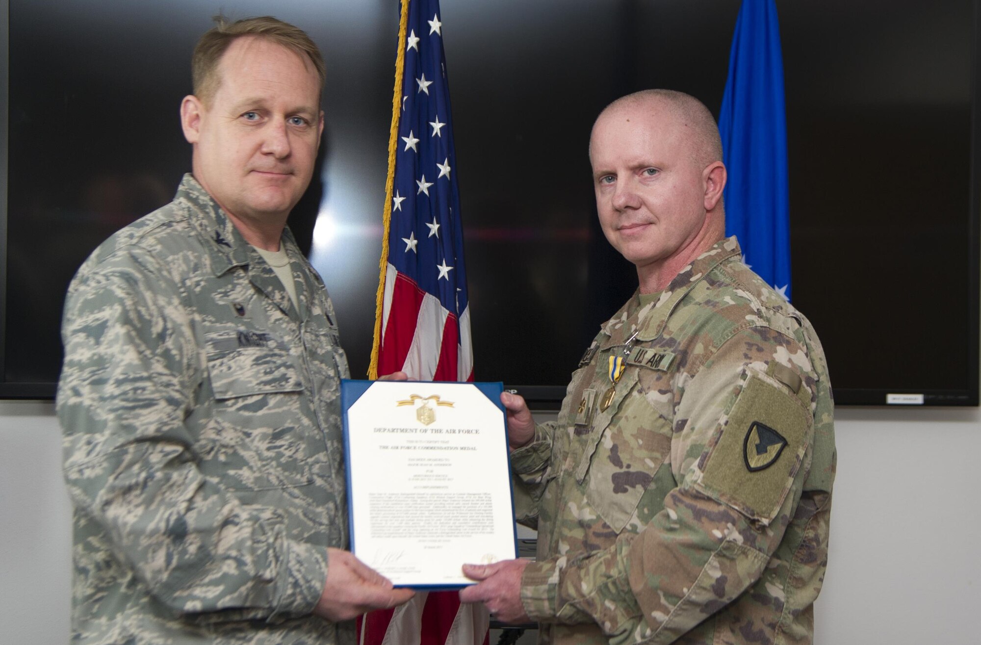 U.S. Army Maj. Sean Anderson, right, and Col. Daniel Knight, 673d Mission Support Group commander, pose for the camera during an Air Force Commendation Medal decoration presentation at Joint Base Elmendorf-Richardson, Alaska, March 31, 2017. While assigned to the 673d Contracting Squadron as a contract management officer, Anderson initiated an expansion of the installation mass notification system more than $295,000. Anderson is assigned to the 673d CONS. 