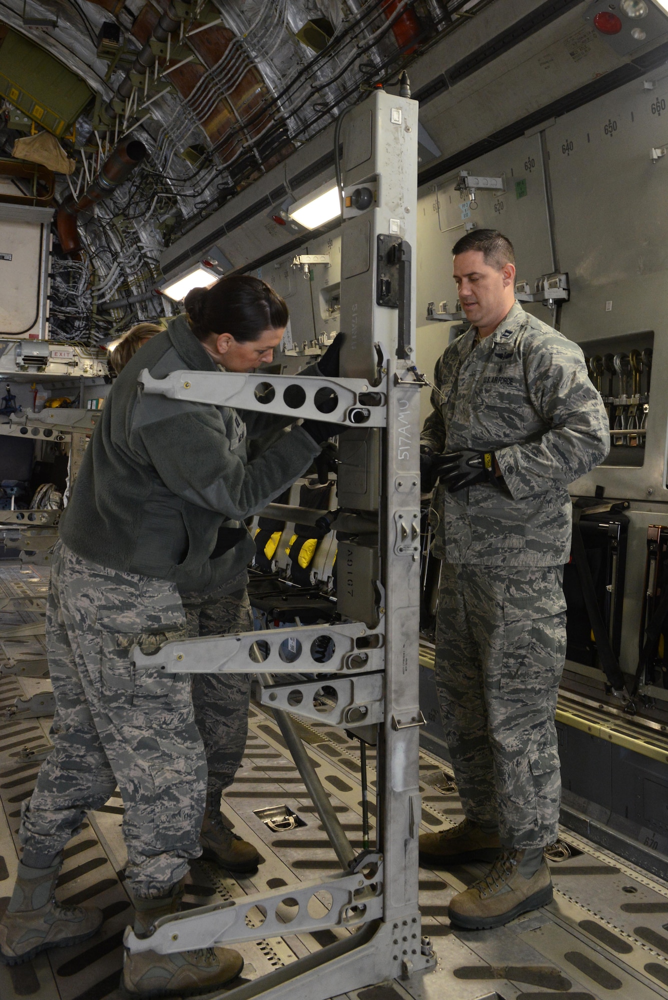 U.S. Air Force captains Paul Padilla (right) and Leslie Mead, 673d Medical Group, build inflight-patient stands inside a C-17 Globemaster III for an EnRoute Patient Staging System exercise at Joint Base Elmendorf-Richardson, Alaska, April 3, 2017. The ERPSS provides patient reception and limited emergent intervention, and ensures patients are medically and administratively prepared for flight in a safe and timely aeromedical evacuation. 