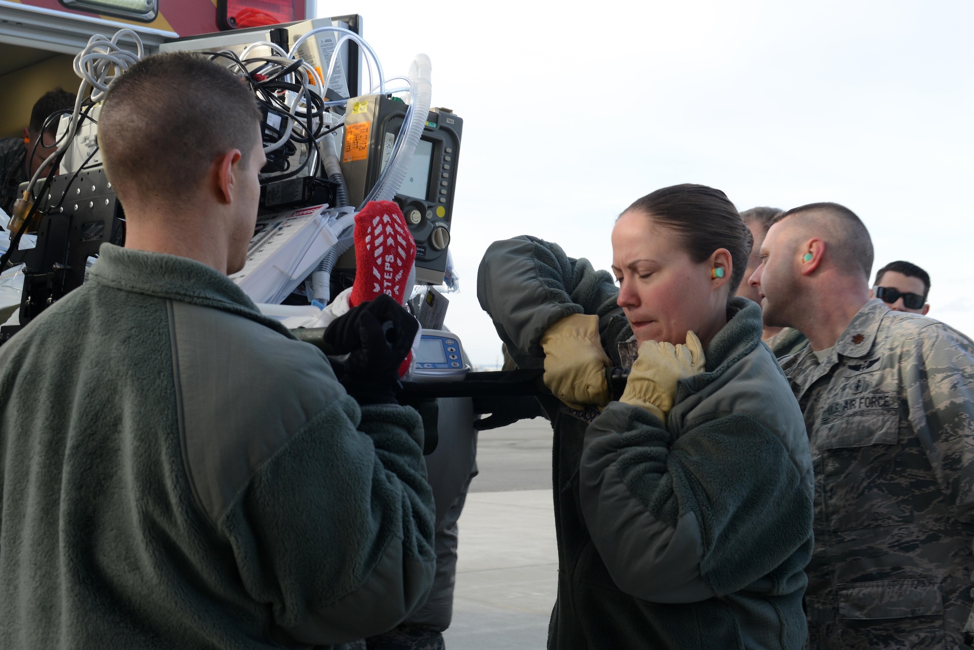 Technical Sgt. Ashley Jackson and other 673d Medical Group Airmen lift a simulated patient and a continuous positive airway pressure machine during the EnRoute Patient Staging System exercise at Joint Base Elmendorf-Richardson, Alaska, April 3, 2017. The ERPSS provides patient reception and limited emergent intervention, and ensures patients are medically and administratively prepared for flight in a safe and timely aeromedical evacuation.
