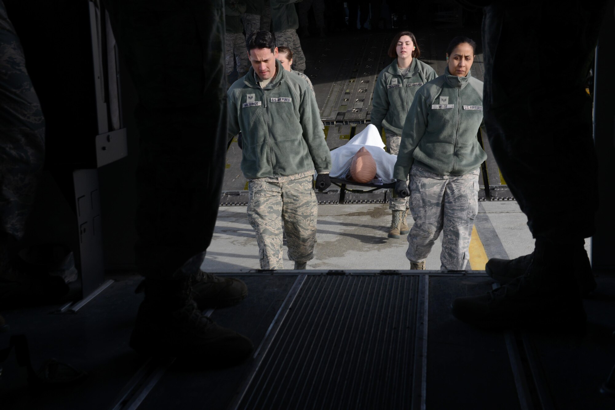 673d Medical Group Airmen transport a simulated patient from a C-17 Globemaster III into a bus during the EnRoute Patient Staging System exercise at Joint Base Elmendorf-Richardson, Alaska, April 3, 2017. The ERPSS provides patient reception and limited emergent intervention, and ensures patients are medically and administratively prepared for flight in a safe and timely aeromedical evacuation.