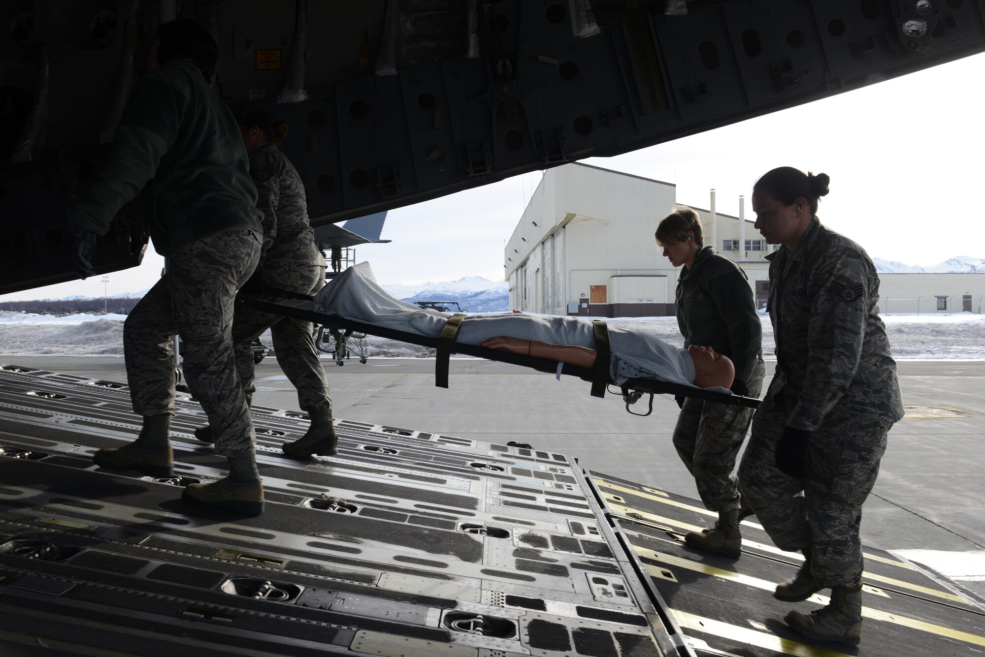 673d Medical Group Airmen transport a simulated patient from a bus into a C-17 Globemaster III during the EnRoute Patient Staging System exercise at Joint Base Elmendorf-Richardson, Alaska, April 3, 2017. The ERPSS provides patient reception and limited emergent intervention, and ensures patients are medically and administratively prepared for flight in a safe and timely aeromedical evacuation.