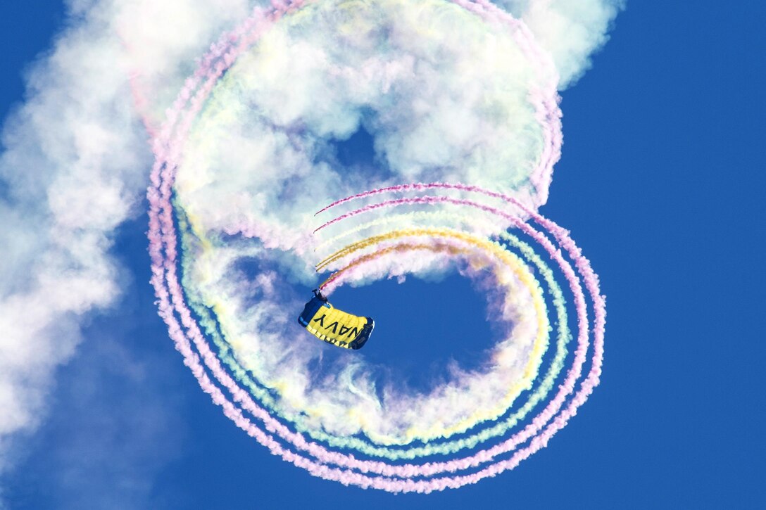 A member of the Leap Frogs, the Navy's parachute demonstration team, creates smoke trails above Popps Ferry Elementary school during Navy Week in Biloxi, Miss., April 4, 2017. The Navy program serves as the Navy's principle outreach effort in areas of the country without a significant Navy presence. Navy photo by Petty Officer 3rd Class Zachary Eshleman