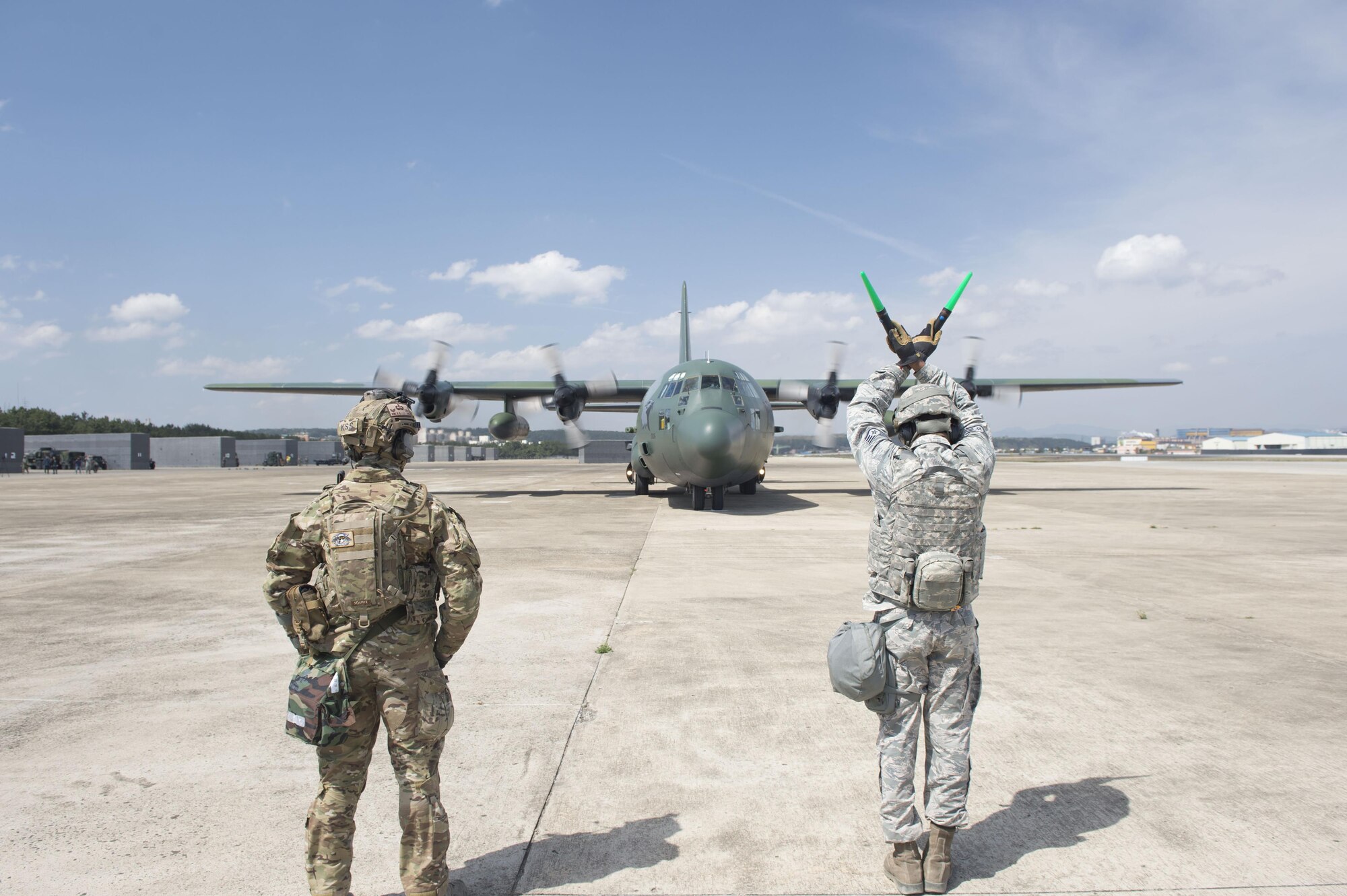 U.S. Air Force Staff Sgt. Courtney Hill, an aircraft maintainer assigned to the 621st Contingency Response Wing stationed at Joint Base McGuire-Dix-Lakehurst, N.J., marshals a ROKAF C-130H as a Republic of Korea Air Force Airman gives instruction during combined training at exercise Turbo Distribution 17-3, at Pohang Air Base, Republic of Korea, April 10, 2017. (U.S. Air Force photo by Tech. Sgt. Gustavo Gonzalez/RELEASED)