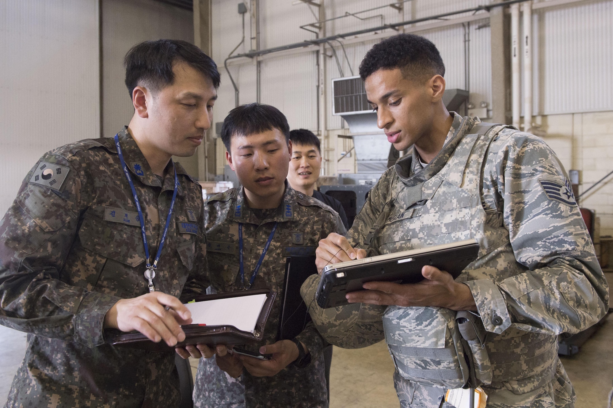 U.S. Air Force Staff Sgt. Robin McClain, a cyber technician assigned to the 621st Contingency Response Wing stationed at Joint Base McGuire-Dix-Lakehurst, N.J., talks about procedures with two Republic of Korea Air Force Airmen during exercise Turbo Distribution 17-3 at Pohang Air Base, Republic of Korea, April 7, 2017. The CRW specializes in rapidly establishing hubs for cargo distribution operations worldwide, to include remote and austere locations, on short notice. (U.S. Air Force photo by Tech. Sgt. Gustavo Gonzalez/RELEASED)