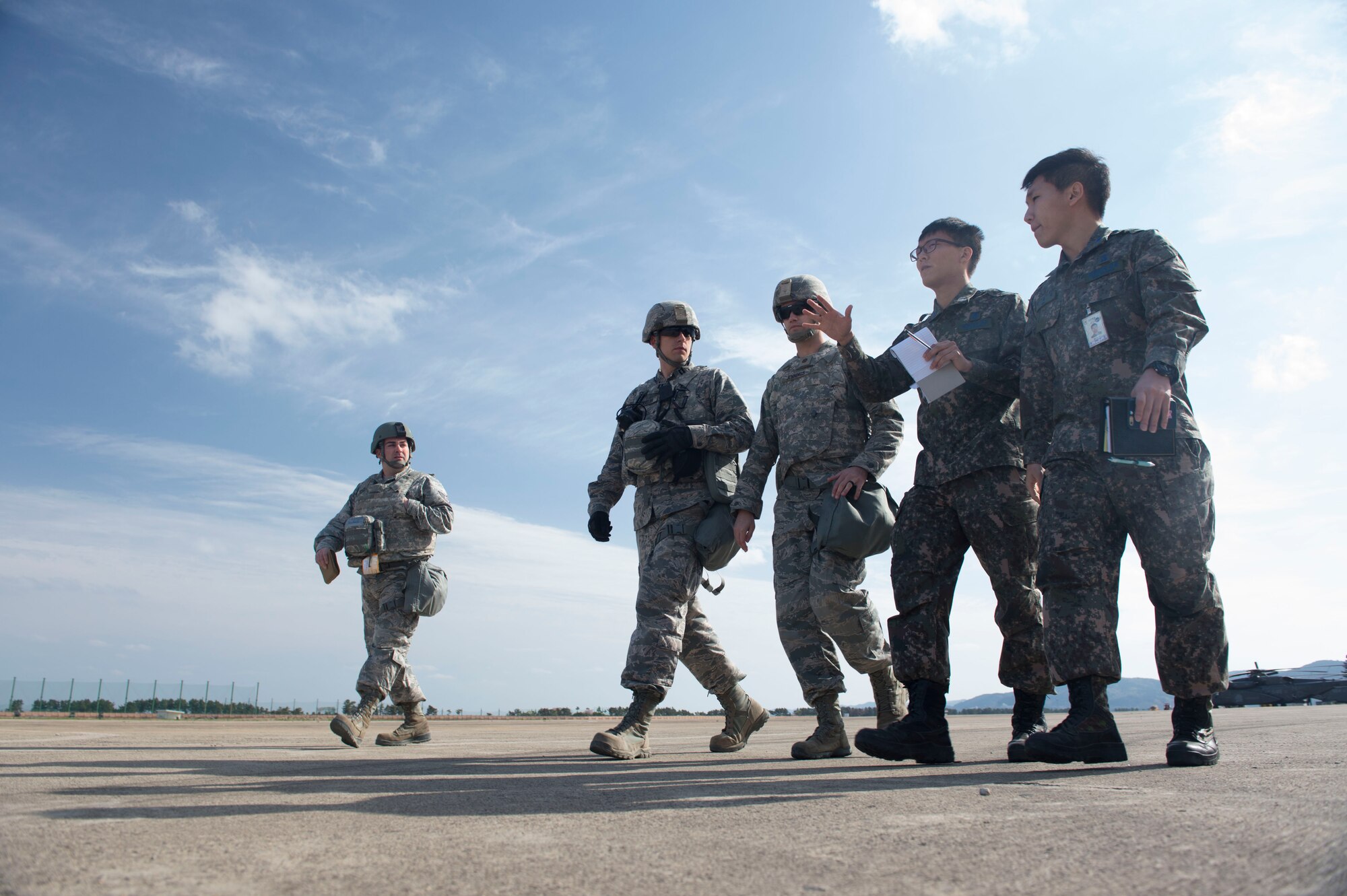 U.S. Air Force Airmen assigned to the 621st Contingency Response Wing stationed at Joint Base McGuire-Dix-Lakehurst, N.J., and Republic of Korea Air Force Airmen walk together to inspect the airfield to determine a parking plan for incoming aircraft during exercise Turbo Distribution 17-3, at Pohang Air Base, Republic of Korea, April 10, 2017. (U.S. Air Force photo by Tech. Sgt. Gustavo Gonzalez/RELEASED)
