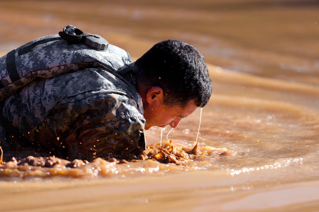 Army Maj. Anthony Aguilar crawls through a water obstacle during the Best Ranger Competition at Fort Benning, Ga., April 7, 2017. Aguilar is a Ranger assigned to U.S. Army Special Operations Command. Army photo by Spc. Darius Davis