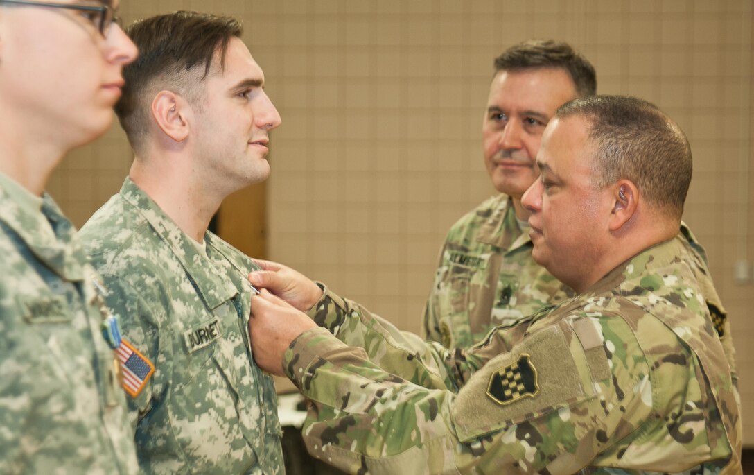 Brig. Gen. Jose Burgos, Deputy Commanding General, 99th Regional Support Command (right) awards Sgt. Shafer Burnett, an Army Achievement Medal after receiving an Army Achievement Medal during a ceremony at Fort Devens Massachusetts, 6 April, 2017. Burnett received the award for finishing as runner-up in the junior-enlisted category of the 99th Regional Support Command's 2017 Best Warrior Competition that took place here 2-6 April.