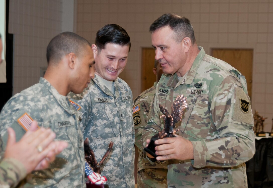 Command Sgt. Maj. Arlindo Almeida, Command Sergeant Major, 99th Regional Support command (right) awards Spc. Aaron Chavers, 198th Army Band (left) and Sgt. Curtis Presley, 380th Army Band (center) their trophies during a ceremony at Fort Devens Massachusetts, 6 April, 2017. The Soldiers received the awards for finishing first place in the Junior Enlisted and Noncommissioned Officer categories respectively of the 99th Regional Support Command's 2017 Best Warrior Competition that took place here 2-6 April. The Soldiers will advance to compete in the U.S. Army Reserve Command’s Best Warrior Competition slated for June.