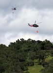 Two UH-60 Black Hawks from the California National Guard carry 600-gallon helicopter buckets and prepare for water drops April 8, 2017, at Pardee Reservoir, Ione, California, during the 2017 Wildland Firefighting Training. The exercise unites the California Guard and California Department of Forestry and Fire Protection (CAL FIRE) as a method of preparing for the upcoming fire season. 