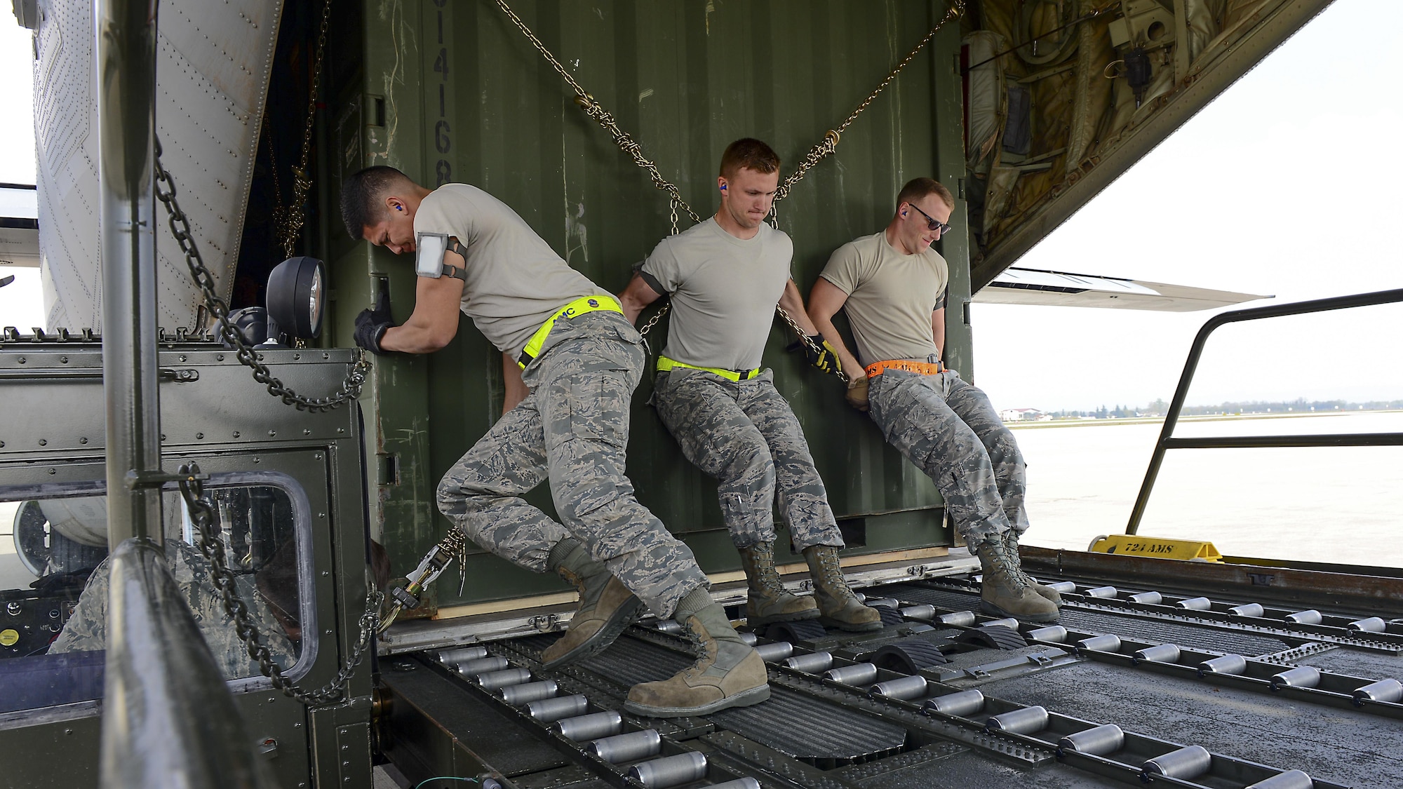 Senior Airman Daniel Zamora, Airman Skylar Keyes and Senior Airman Timothy Flowers, 724th Air Mobility Squadron passenger service agents, push a shipping crate onto a C-130 Hercules at Aviano Air Base, Italy, April 6, 2017.  Airmen from the 724th AMS support more than 500 airlift missions a year.  (U.S. Air Force photo by Airman 1st Class Ryan Brooks)