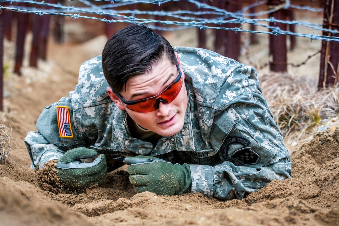 Army Reserve Sgt. Curtis Presley crawls under a barbed-wire obstacle during the Best Warrior Competition at Fort Devens, Mass., April 5, 2017. Army Reservists assigned to the 80th Training Command and 99th Regional Support Command participated in the event. Army photo by Staff Sgt. Timothy Koster