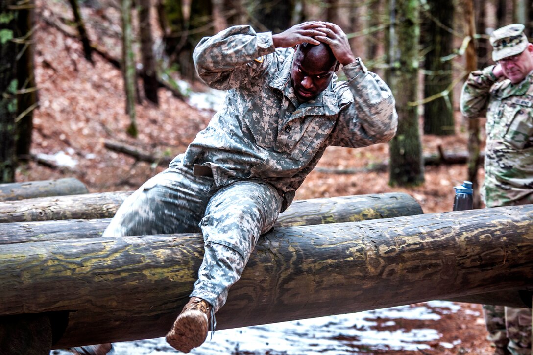 Army Reserve Staff Sgt. Harry John II maneuvers over a log obstacle during the Best Warrior Competition at Fort Devens, Mass., April 5, 2017. Army photo by Staff Sgt. Timothy Koster 