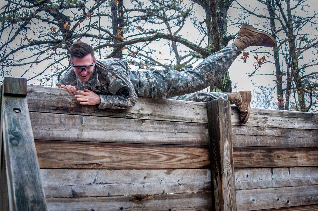 Army Reserve Sgt. Shafer Burnett climbs over the high wall obstacle during the Best Warrior Competition at Fort Devens, Mass., April 5, 2017. Army photo by Staff Sgt. Timothy Koster